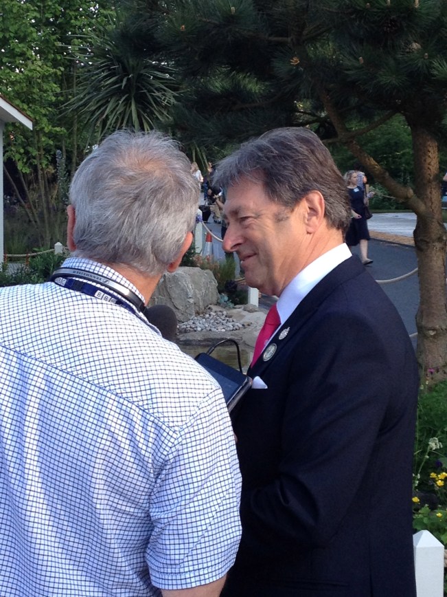 I was so delighted to finally meet and have a chat with the so-called "Housewife's Choice" of English female gardeners of a "certain" age. For those of you reading this in America, Alan is a charming man and THE Superstar of English gardening. A prolific garden writer and a champion of all things horticultural, Alan has taken on the challenge of designing a garden to celebrate the 50th Anniversary of "Britain in Bloom". for he RHS. This civic beautification program started not long after the Second World War. Begun to re-invigorate the British gardening interest and to brighten up towns and villages across the country, it has achieved this goal and then some. Gardening together has helped communities to feel more local pride and that pulling together spirit that I was always told as a child was there during the war.A little friendly competition between neighboring villages does not hurt either. Alan worked with another Chelsea Gold medal winner, Kate Gould, to design and implement this gaden that shows the diversity of plants that can be grown in the British Isles. The back of the exhibit is a representation of Alan's native Ilkley Moor in Yorkshire, complete with a dry-stone wall removed from the Moors and re-installed here at Chelsea. Silver Birch trees dot the grassy areas as the slope falls down to the pool and cabin that represent the more temperate growing area of Alan's present home on the Isle of Wight.  The garden is a fitting tribute to both Alan's fifty years in gardening and the half a century of Britain in Bloom. By the way Alan (and all of the other exhibitors) must be exhausted. I talked to him early this morning when he really wanted a cup of coffee and I have just seen photos of him chatting with the Queen on the Telly (Television- translation) this evening