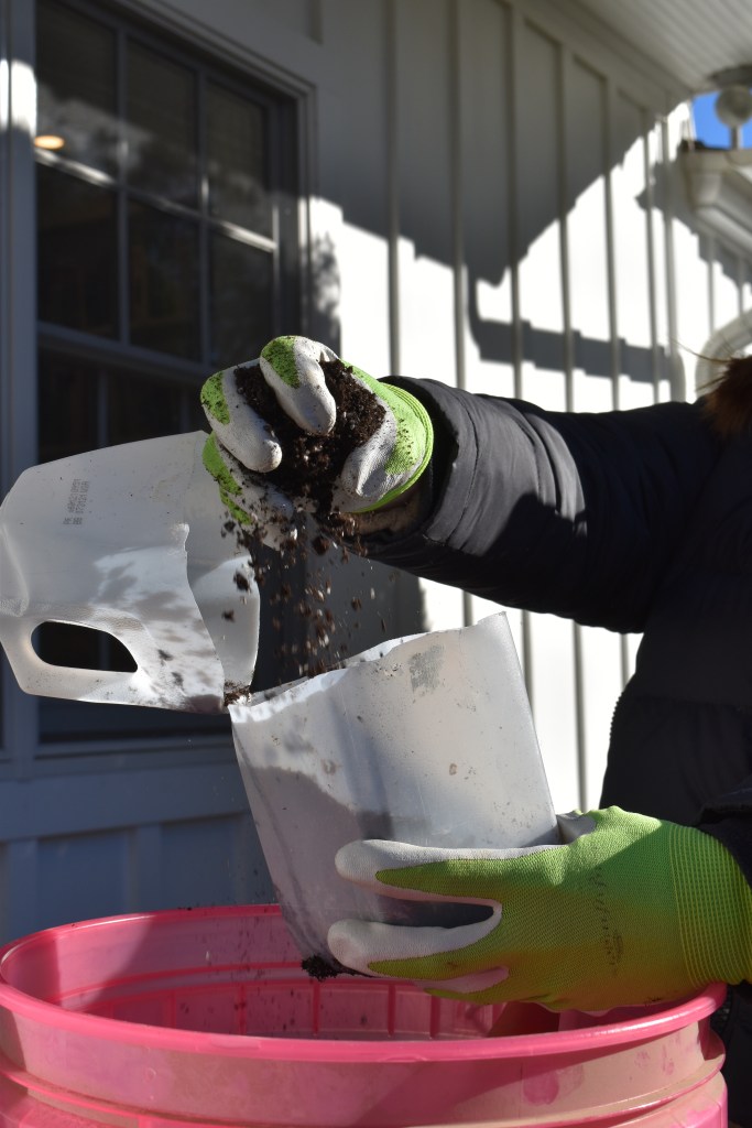 A garden container being filled with potting mix