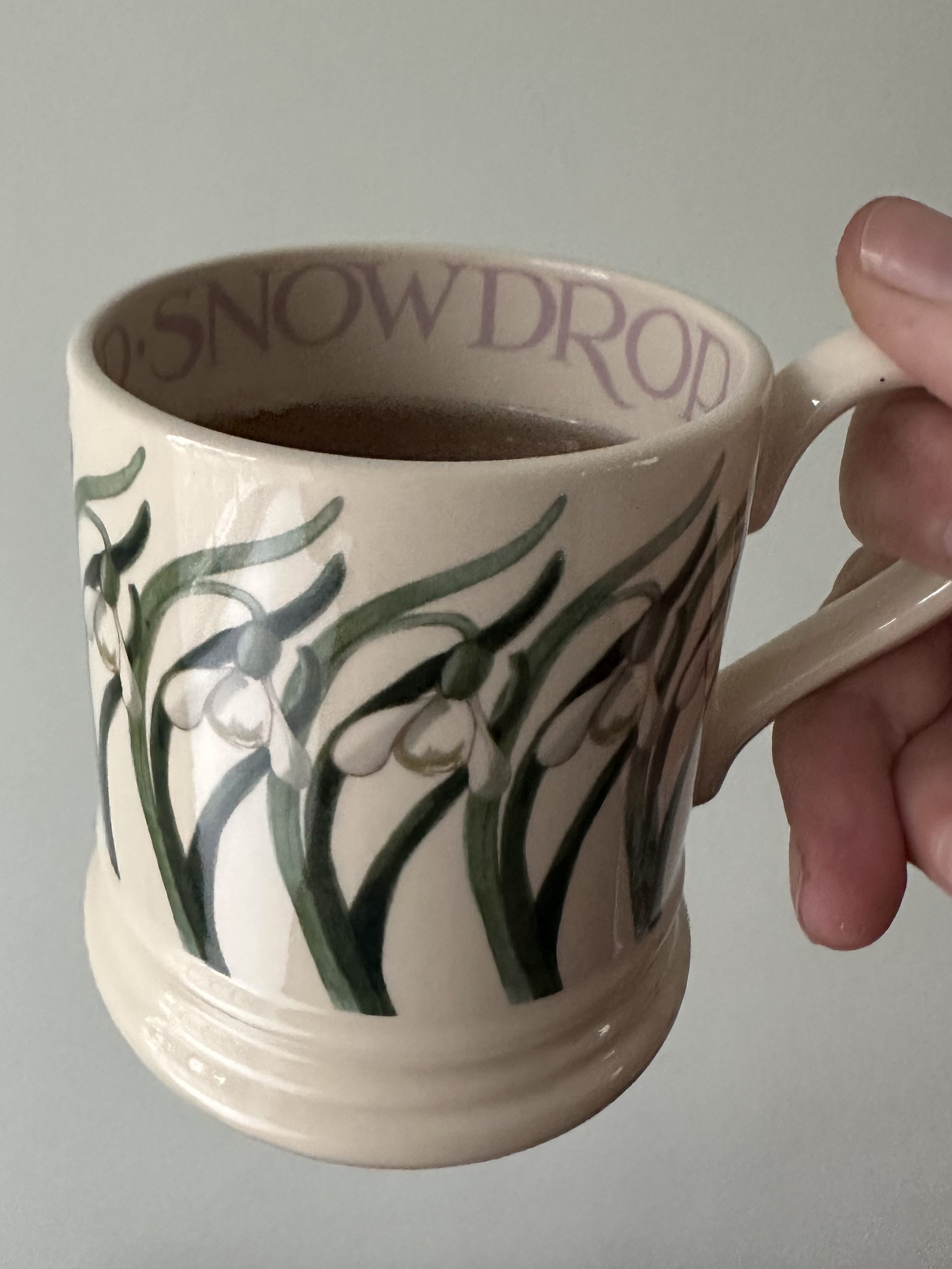 Emma Bridgewater tea cup with snowdrop pattern on it - a type of English pottery