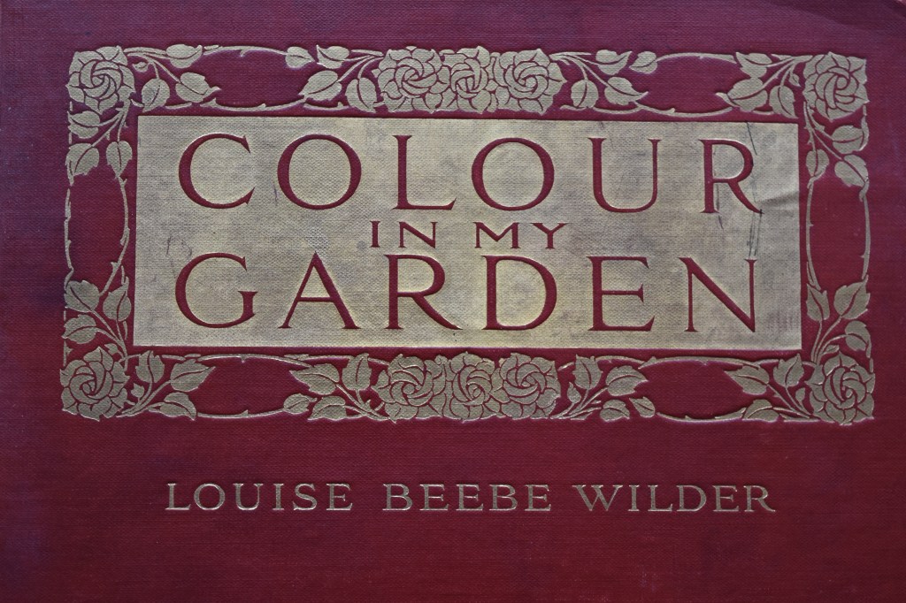 Front Cover of an old book with gold title on a maroon background - title reads Colour in My Garden, Louise Beebe Wilder