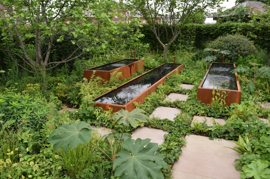 Stell troughs filled with vibrating water in a Chelsea garden