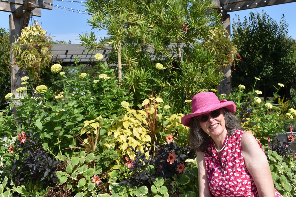 Jenny Rose Carey in a pink dress and pink hat at the Olbrich Botanical Gardens in Maddison Wisconsin