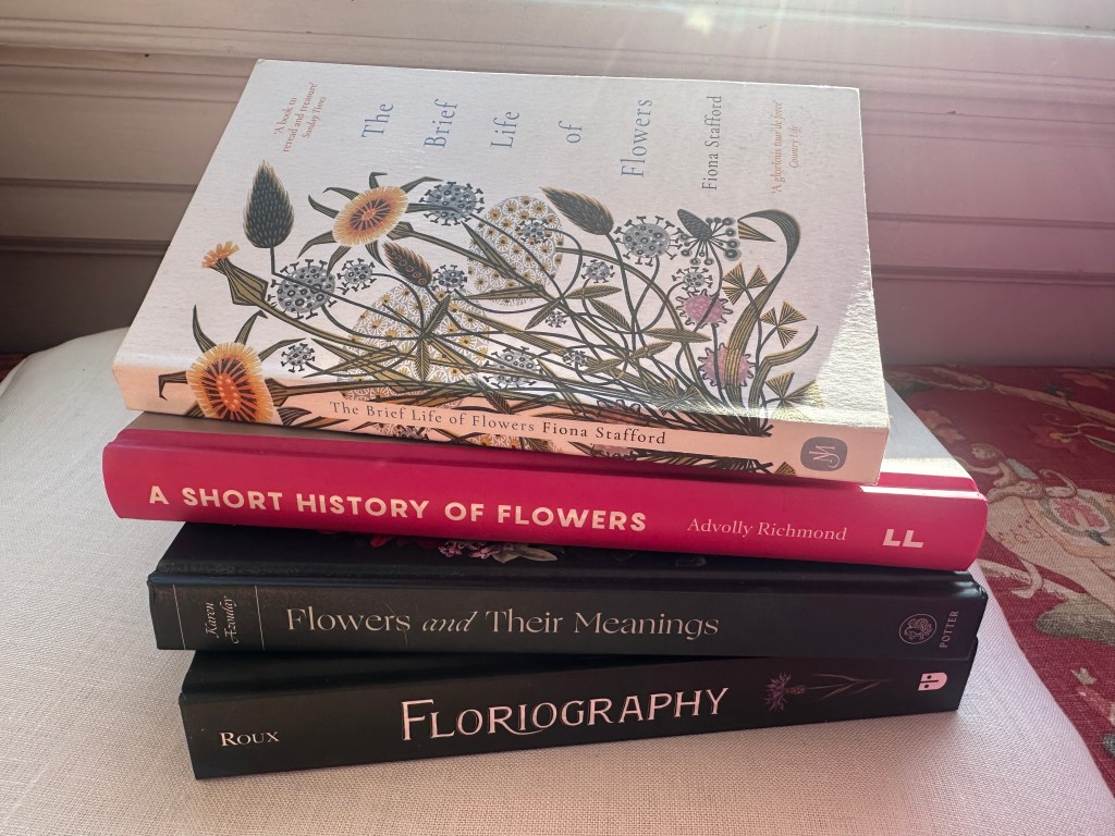 A pile of four flower history books that make great winter reading