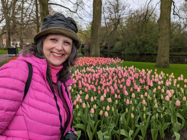 Jenny Rose Carey at the bulb garden - Keukenhof in the Netherlands with Tulips behind her.