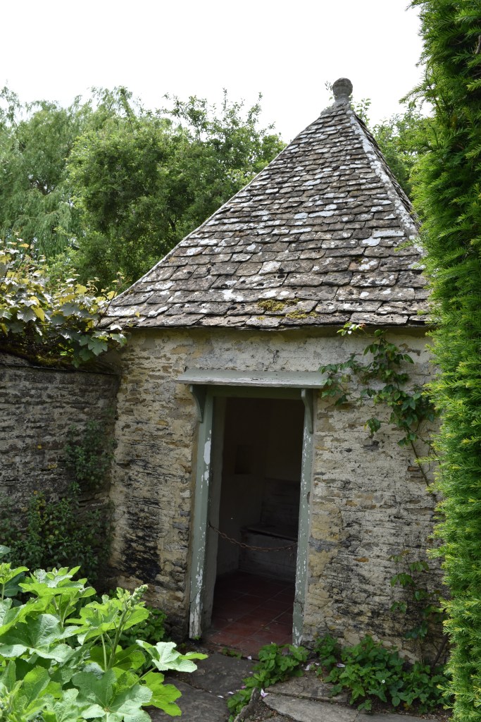 The much photographed garden privy with stone roof and ball on top.