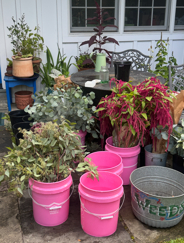 Pink buckets and flowers waiting to be arranged
